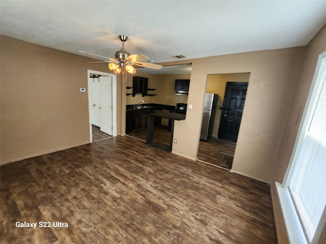 kitchen featuring ceiling fan, dark hardwood / wood-style floors, sink, and stainless steel refrigerator