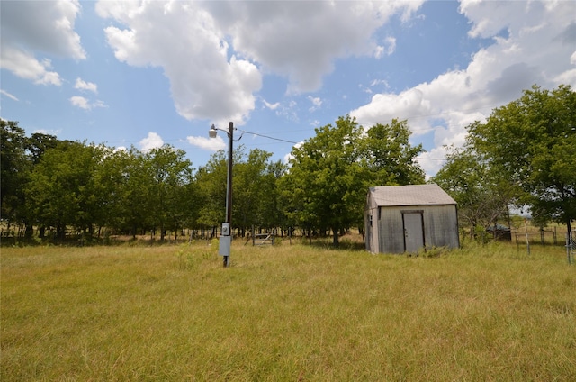 view of yard featuring a rural view and a storage shed