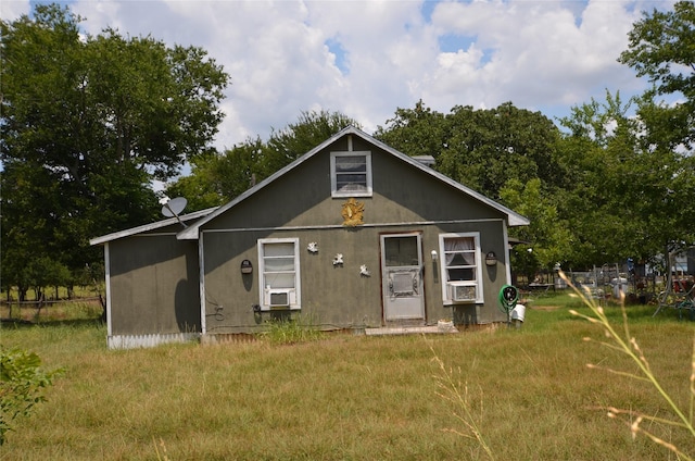 bungalow-style house with a front lawn and cooling unit