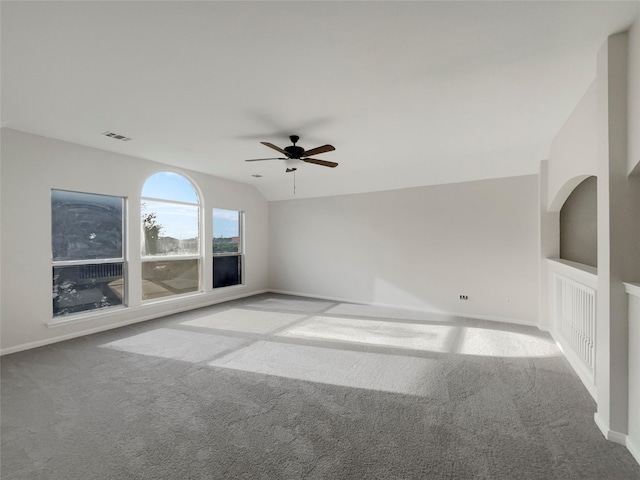 empty room featuring vaulted ceiling, light colored carpet, and ceiling fan