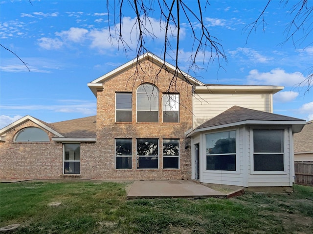 rear view of property featuring a patio area and a lawn