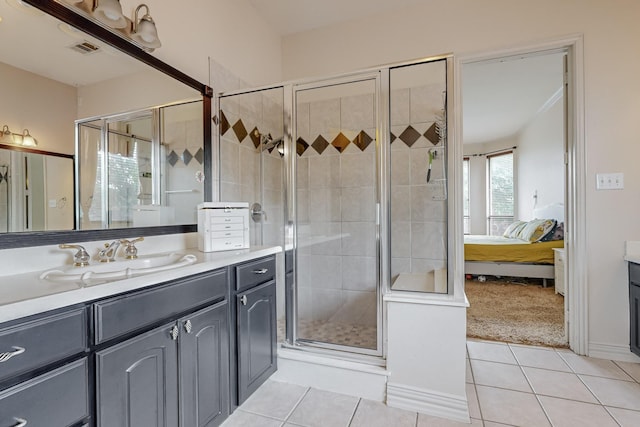 bathroom with tile patterned floors, a shower with shower door, and vanity