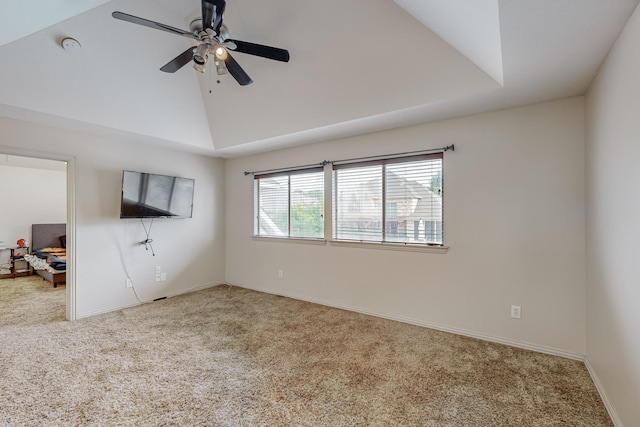 carpeted spare room with lofted ceiling, a tray ceiling, and ceiling fan