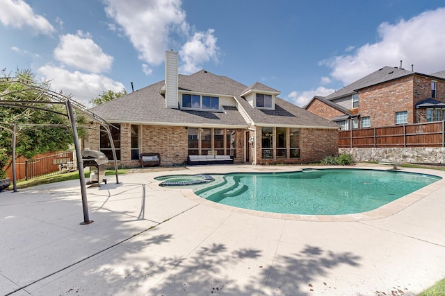 view of swimming pool featuring an in ground hot tub and a patio area