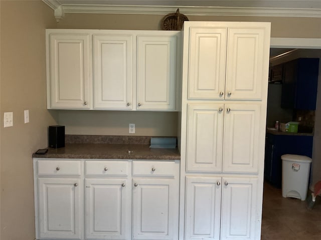 kitchen with white cabinets, tile patterned flooring, and ornamental molding