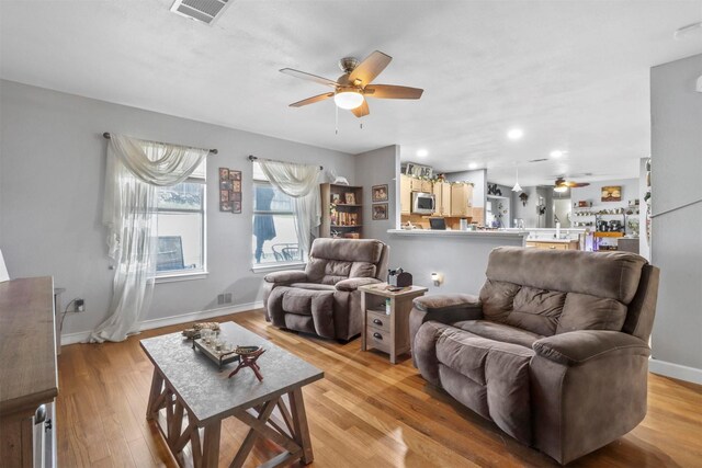 living room featuring light hardwood / wood-style flooring and ceiling fan