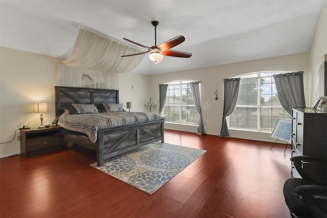 bedroom with dark hardwood / wood-style flooring and ceiling fan