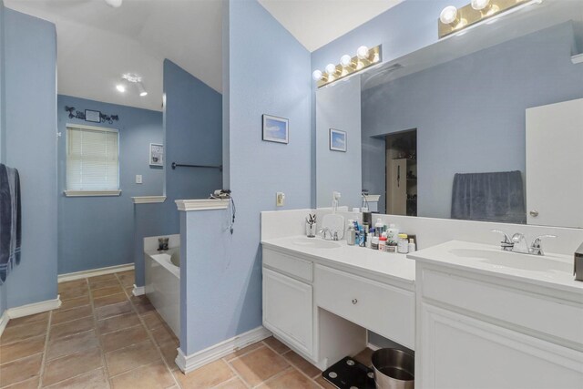 bathroom with tile patterned floors, dual bowl vanity, and a bathtub