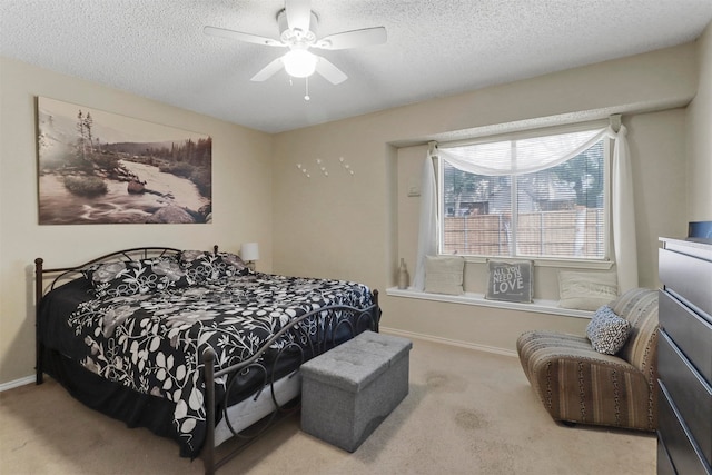 carpeted bedroom featuring a textured ceiling and ceiling fan