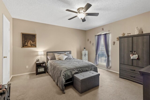 carpeted bedroom featuring a textured ceiling and ceiling fan