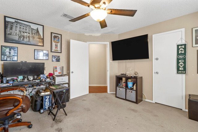 home office with light carpet, a textured ceiling, and ceiling fan