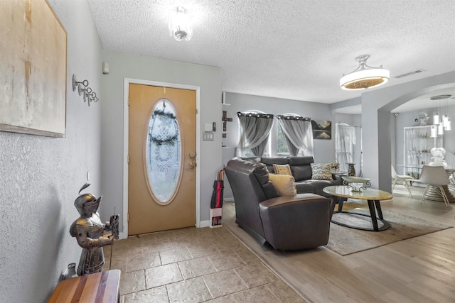 entryway with a textured ceiling and light hardwood / wood-style floors