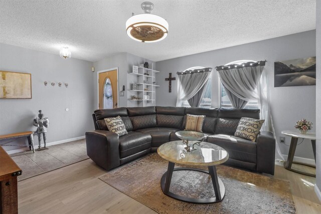 living room featuring light wood-type flooring and a textured ceiling