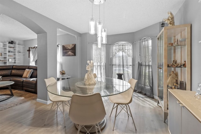 dining room with a textured ceiling and light wood-type flooring