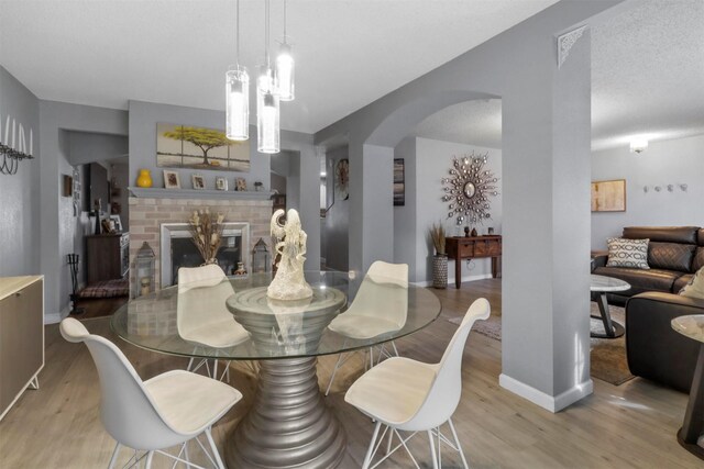 dining room with a fireplace and light hardwood / wood-style floors