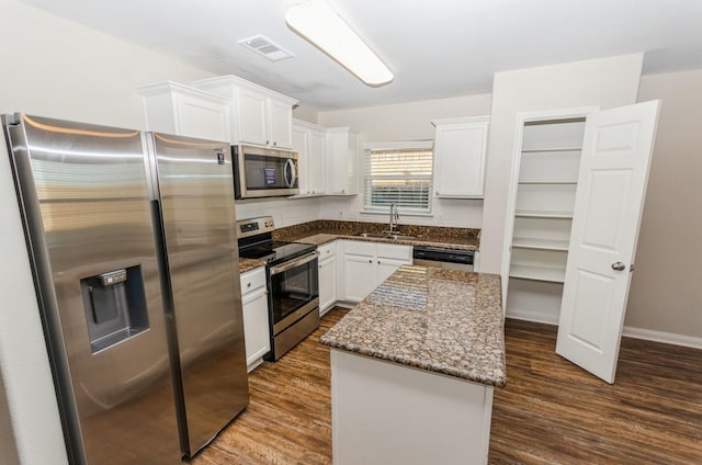 kitchen featuring white cabinetry, a kitchen island, dark hardwood / wood-style floors, and appliances with stainless steel finishes