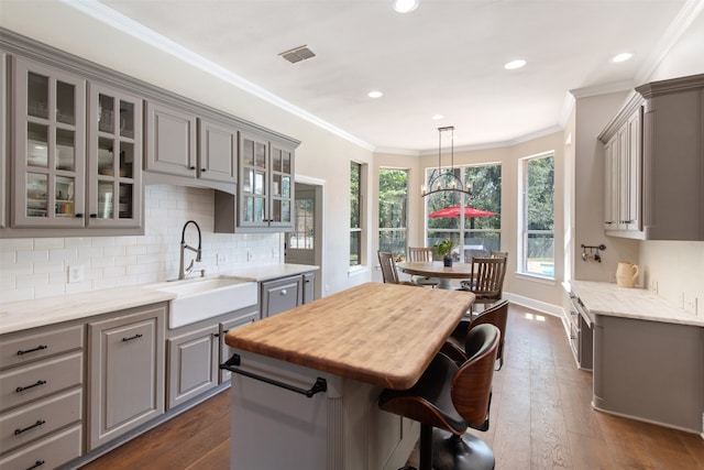 kitchen featuring gray cabinetry, pendant lighting, sink, and dark hardwood / wood-style flooring