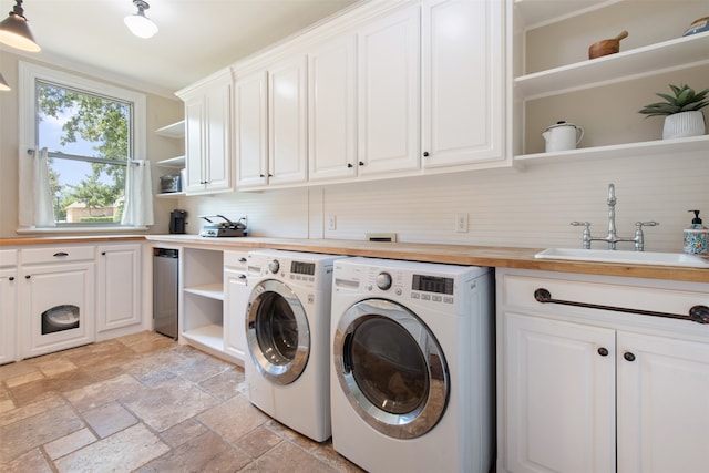 laundry area featuring washer and dryer, cabinets, and sink