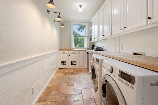 clothes washing area featuring cabinets and washer and clothes dryer