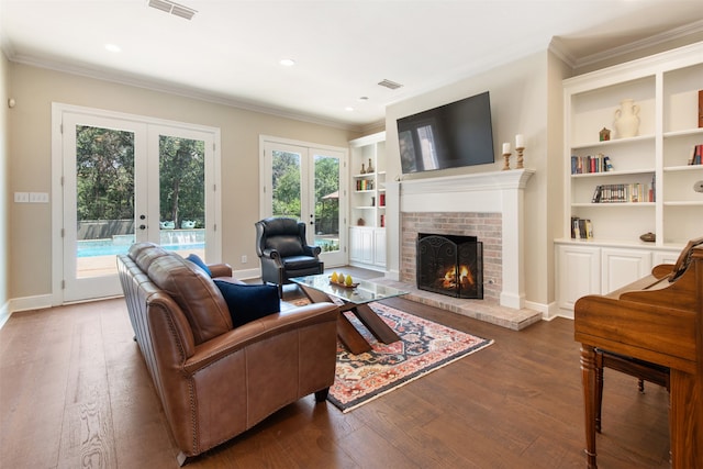 living room featuring french doors, a brick fireplace, wood-type flooring, and a healthy amount of sunlight