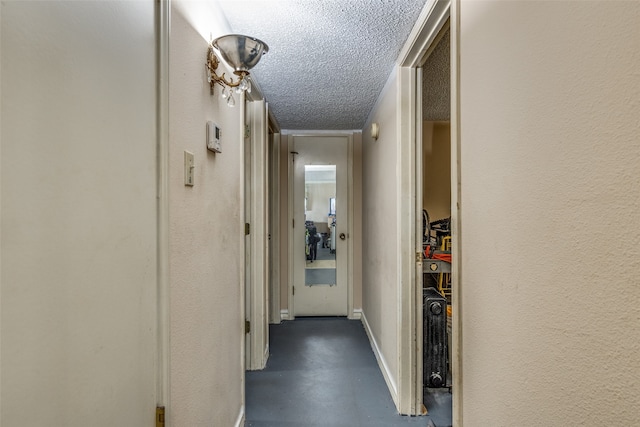 hall featuring a textured ceiling