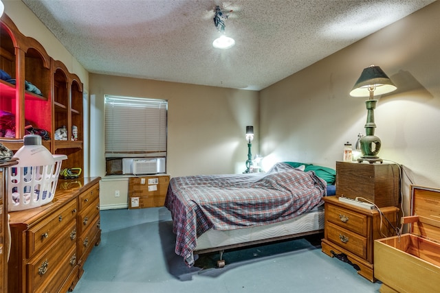 bedroom featuring a textured ceiling, concrete floors, and cooling unit