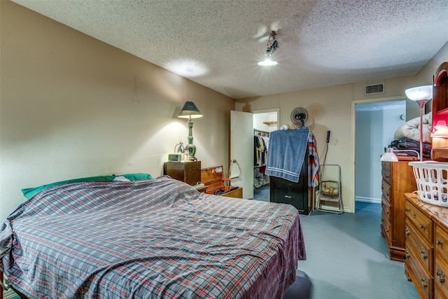 bedroom with a textured ceiling, a closet, and concrete flooring