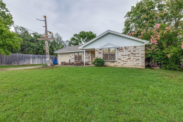 view of front facade with driveway, an attached garage, fence, a front yard, and brick siding