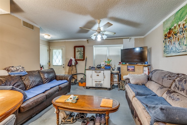 living room featuring ceiling fan, a healthy amount of sunlight, and a textured ceiling