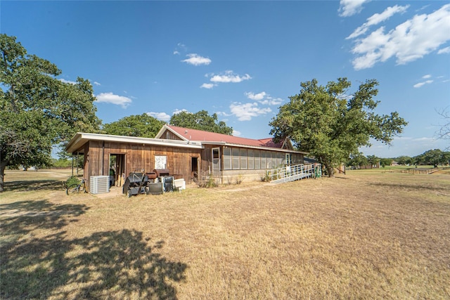 back of house with a lawn and central air condition unit