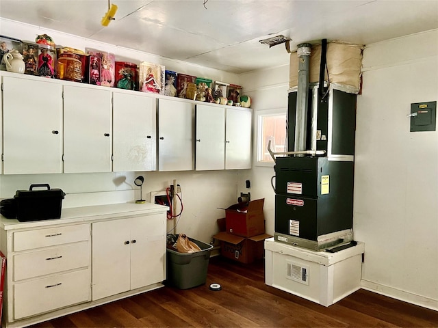 kitchen featuring white cabinetry, dark hardwood / wood-style flooring, heating unit, and electric panel