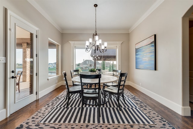 dining area with an inviting chandelier, crown molding, and dark hardwood / wood-style floors