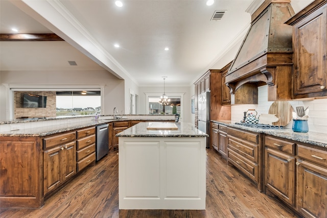 kitchen with dark hardwood / wood-style floors, light stone counters, backsplash, and a kitchen island