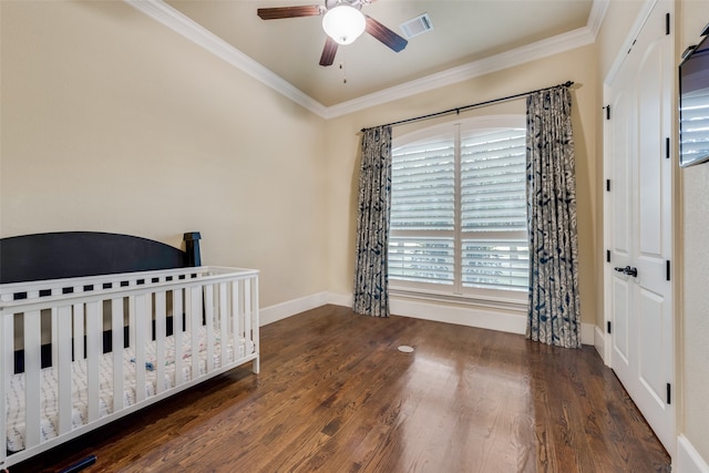 bedroom with ceiling fan, ornamental molding, dark hardwood / wood-style flooring, and a nursery area