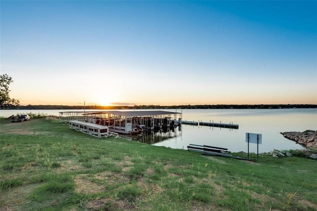 dock area featuring a lawn and a water view