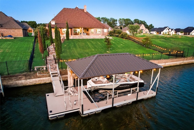 view of dock featuring a water view, a patio area, and a yard