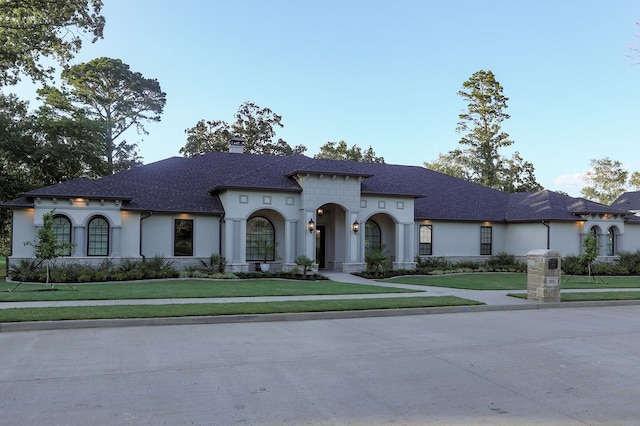 mediterranean / spanish-style home with a front yard