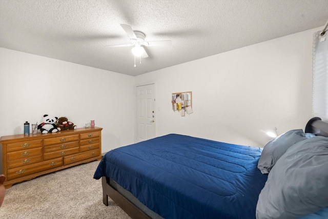 carpeted bedroom with ceiling fan and a textured ceiling