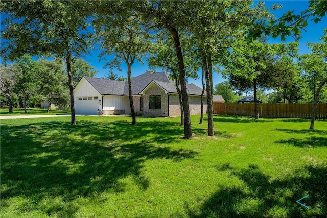 view of front of home with a garage, fence, board and batten siding, and a front lawn