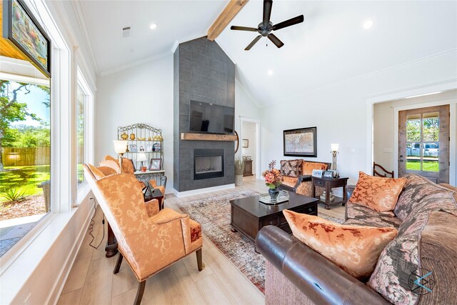 living room featuring a fireplace, vaulted ceiling with beams, light wood-type flooring, and ceiling fan