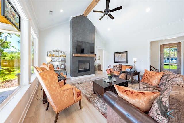 living room featuring a large fireplace, visible vents, light wood-style flooring, ornamental molding, and beam ceiling