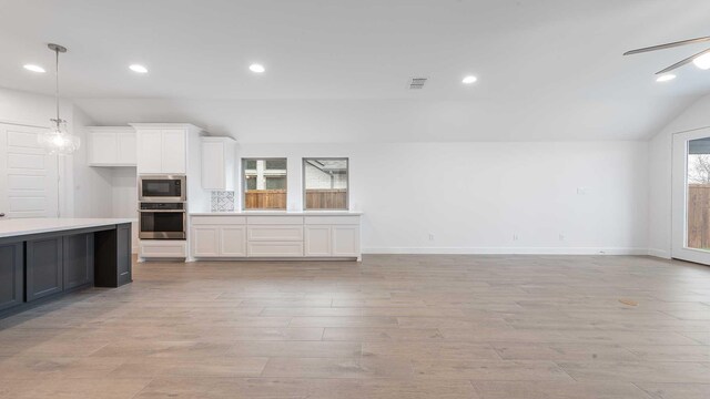 kitchen with white cabinetry, stainless steel appliances, light hardwood / wood-style floors, lofted ceiling, and decorative light fixtures