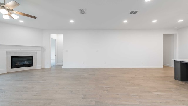 unfurnished living room with ceiling fan and light wood-type flooring