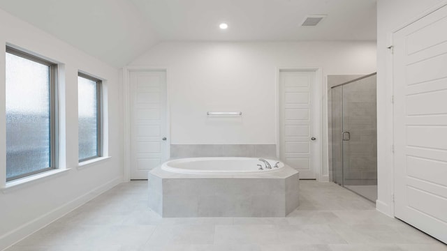 bathroom with tile patterned floors, plenty of natural light, lofted ceiling, and plus walk in shower