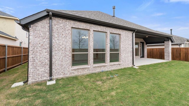 back of house featuring a patio area and a lawn