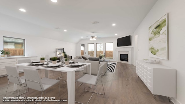 dining room featuring ceiling fan, hardwood / wood-style floors, and lofted ceiling