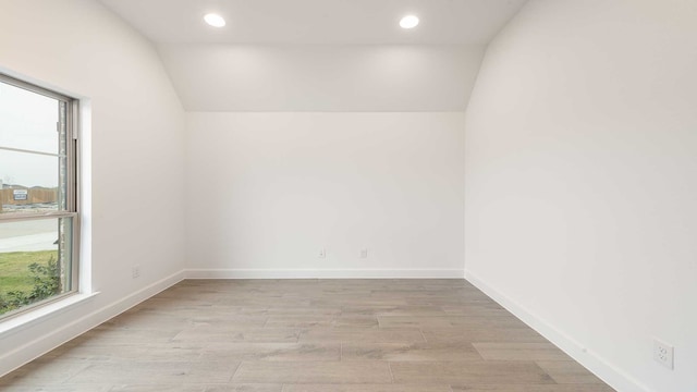 unfurnished room featuring vaulted ceiling and light wood-type flooring