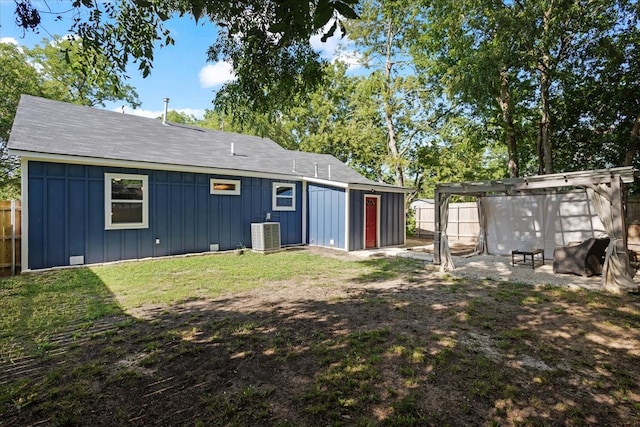 rear view of house with a yard and cooling unit