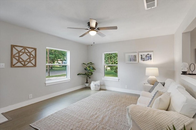 living area featuring ceiling fan, plenty of natural light, and wood-type flooring