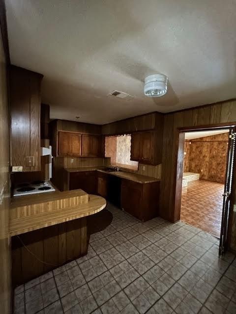 kitchen with white stovetop and wooden walls